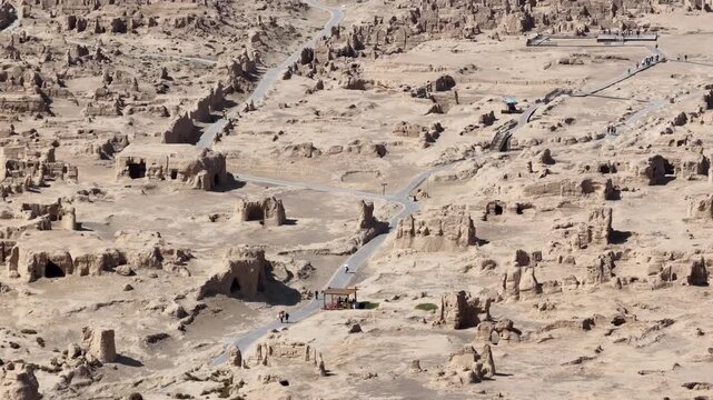 Aerial view of the ancient Jiaohe ruins showcasing eroded structures and pathways cutting through the arid landscape, Turpan, China.