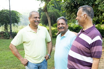 Obraz premium Indian happy retired elderly friends fun and bonding outdoors at park. Indian Asian old people having fun and spending time together, concepts about elderly, seniority, wellness aging and fun together