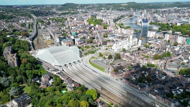Aerial view of the modern Li&egrave;ge-Guillemins railway station, surrounded by a dense cityscape with the Meuse river winding through it, Li&egrave;ge, Wallonia, Belgium.