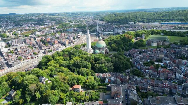 Aerial view of the Cointe Intermodal Terminal, a mix of urban buildings, green trees, and a prominent monument, Li&egrave;ge, Wallonia, Belgium.