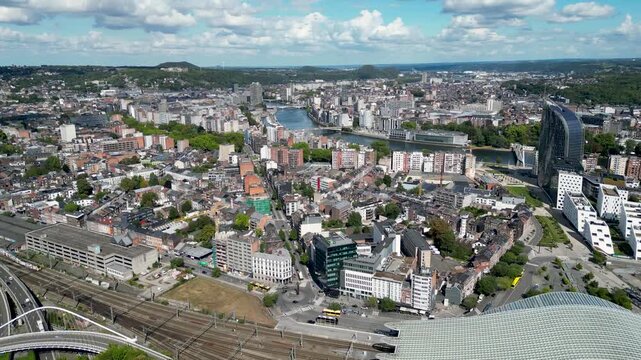 Aerial view of the modern architecture of Li&egrave;ge-Guillemins train station contrasting with the city's skyline and the winding river, Li&egrave;ge, Wallonia, Belgium.