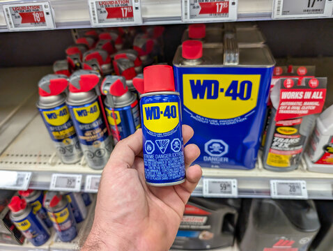 Quebec, Canada, 15 July 2025 : Hand Holding Blue WD Forty Can In Automotive Store Product Aisle