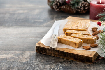 Christmas soft almond nougat bar with christmas decoration on wooden table. Copy space