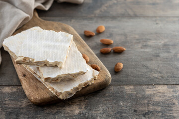 delicious almond nougat on wooden table. Traditional Christmas sweet. Copy space