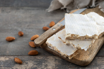 delicious almond nougat on wooden table. Traditional Christmas sweet. Copy space