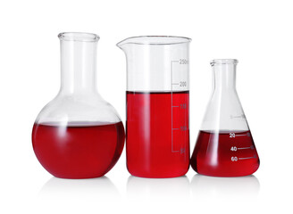 Different laboratory glassware with red liquid isolated on white
