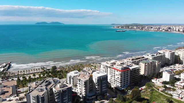 Aerial drone view of the stunning Albanian Riviera coastline, near the city of Vlora, Saranda showcasing pristine white beaches, turquoise sea water, cliffs and mountains under the Mediterranean sun.