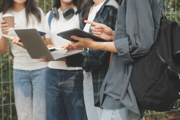 Happy students walking together on university campus, chatting and laughing outdoors after classes
