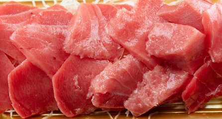 Rough cuts of high-quality medium fatty tuna (maguro) or chutoro as sold in fish markets. Shredded Daikon beneath the maguro.