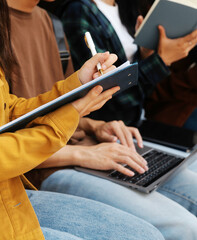 Happy students walking together on university campus, chatting and laughing outdoors after classes