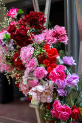 Vibrant artificial flowers display in shades of pink and red.