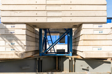Looking through stacked counterweights of a crane on a construction site.