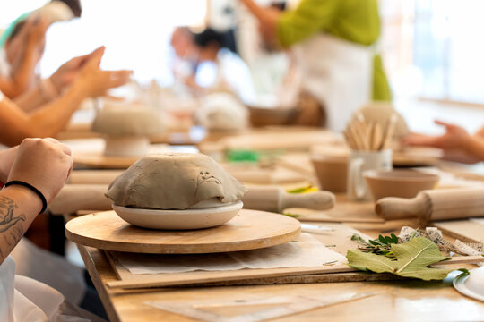 Hands creating pottery during ceramics workshop