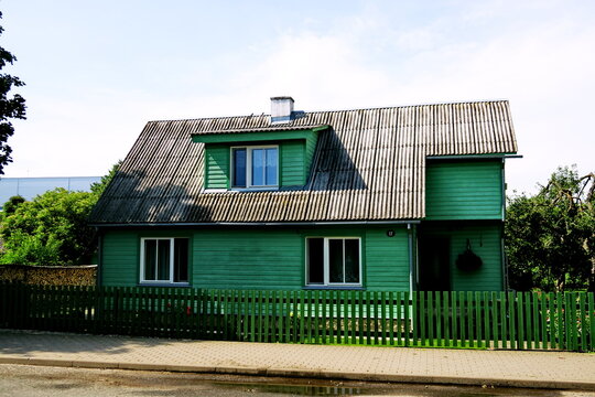 Maison en bois  individuelle peinte en vert. 