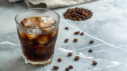 Iced coffee in clear glass on marble table with scattered coffee beans and light linen napkin in background, top view refreshing drink setup for cafe menu or beverage content