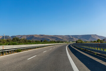 Scenic highway surrounded by hills under clear sky. High quality photo