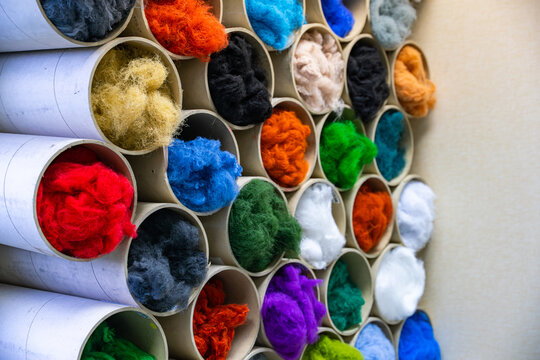 Morceaux de laine de diff&eacute;rentes couleurs formant une composition textile vibrante et riche en textures.