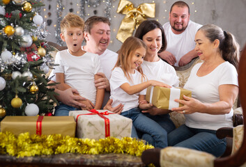 Family with children holding gifts in christmas interior
