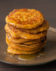 A close-up stock photo of a stack of fluffy pumpkin spice pancakes topped with syrup