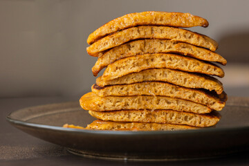 stack of pumpkin spice pancakes with a slice showing the fluffy texture