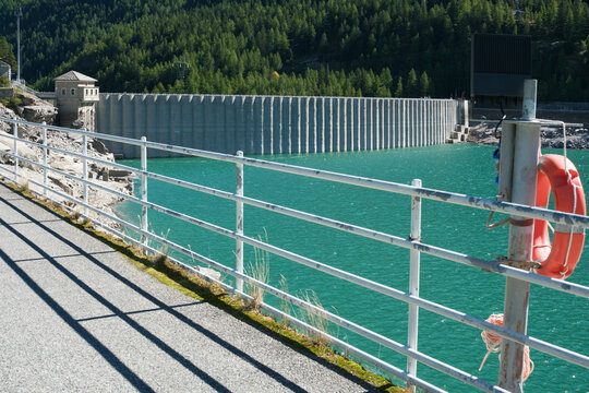 Wide panoramic view of Tre Levanne peaks above Lake Ceresole Reale in Piedmont, Italy. A clear, sunny alpine day showcasing the beauty of the Gran Paradiso mountains and the pristine natural landscape