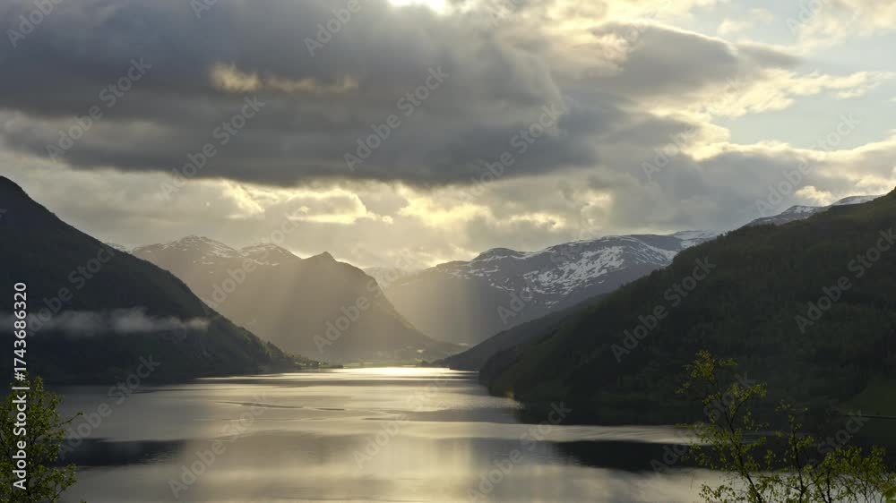 Wall mural timelapse shot of sunrise at lake haukedalsvatnet in norway. the clouds drift gently across the land