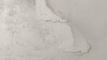 Close-up of a water-damaged ceiling showing damp stains and peeling paint from a roof leak, requiring home repair © Prime