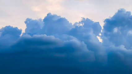 A stunning and dramatic natural phenomenon, vast dark blue and grey clouds fill the sky, creating a...