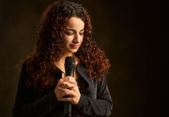Female singer performing song holding microphone