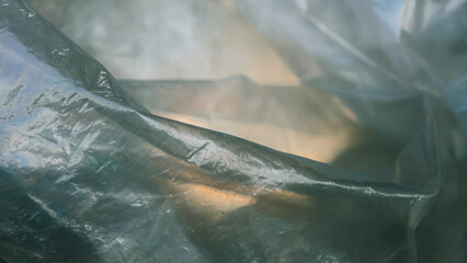 Subtle light through the folds of translucent plastic, a symphony of shadow and light is created