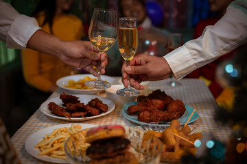 Happy friends celebrating Christmas at home Friends gather at home for a traditional Christmas dinner, young couples enjoying the festive food.