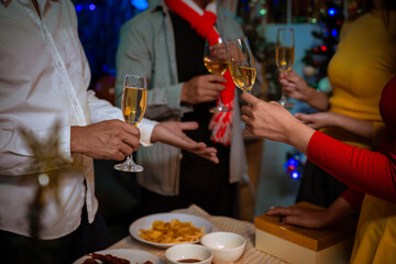 Happy friends celebrating Christmas at home Friends gather at home for a traditional Christmas dinner, young couples enjoying the festive food.