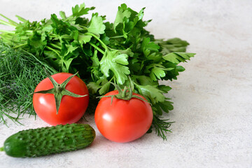 Fresh Tomatoes, Cucumber and parsley on a gray Surface