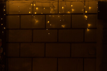 A beautifully crafted wall is elegantly adorned with shining yellow string lights, creating a warm ambiance