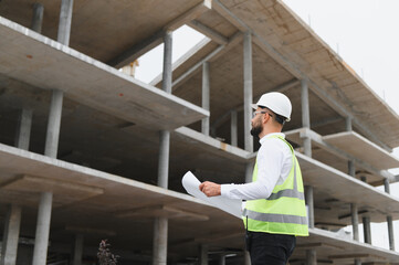 Fototapeta premium Engineer examining blueprint at construction site
