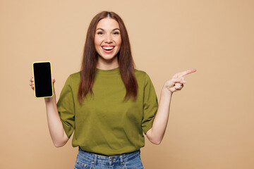 Young woman wears olive green t-shirt casual clothes hold in hand use mobile cell phone with blank...