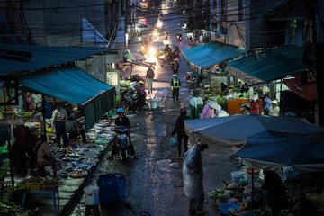 Typical night market. Vending tables groaning with fresh fish, exotic fruits and vegetables. Male and female buyers walking along stalls