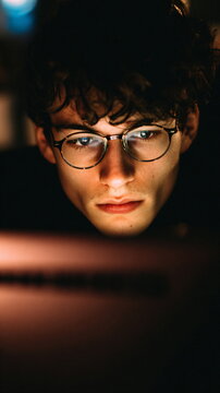 Focused young tech professional intensely concentrating on computer screen in modern workspace