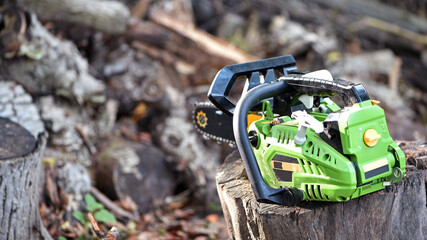 Chainsaw. saws a log with a chainsaw, prepares firewood for winter, hard rural work. A chainsaw stands on a stump, logs need to be cut into firewood. Close-up. gasoline tool