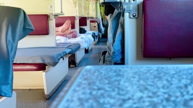 A table in a compartment of a reserved seat train car. First-person view.