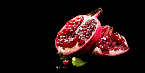 Pomegranate. Fresh juicy Pomegranates with leaves isolated on black background with reflection. Organic Bio fruits closeup. Studio shot 