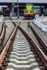 Fototapeta premium A railway station. Rails on concrete sleepers. locomotive and wagons are parked.