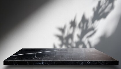 empty dark marble table top with shadow drop on white wall background