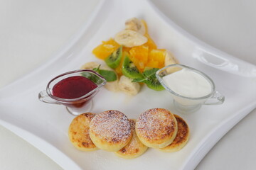 Cottage cheese pancakes with cream sauce and blueberries. syrniki 