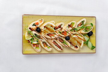 Rolls vegetables olives Delicious rolls of fried zucchini slices and feta cheese with rucola, served with olive oil and pieces of bell peppers