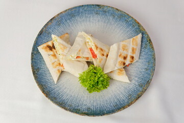 Pita salad serving Shawarma, Gyro pita. Greek food, sliced meat, potato, tomato and tzatziki, paper wrap served in a plate, close up view. 