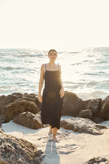 Young woman in a slip dress enjoys the sun at Miami Beach by the ocean