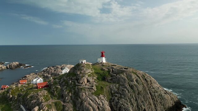 Drone footage shows the surroundings of Kap Lindesnes in Norway at sunset. The camera moves quickly toward the lighthouse, revealing more and more details of the region's landmark.