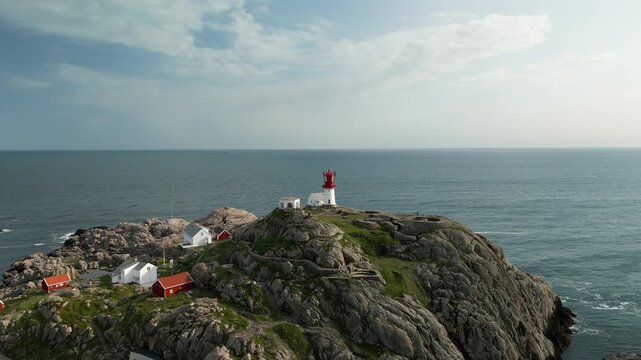 Drone footage shows the surroundings of Kap Lindesnes in Norway at sunset. The camera pans around the lighthouse, the region's landmark.