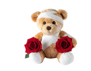 A teddy bear wrapped in gauze holds red roses, conveying a message of comfort and care.